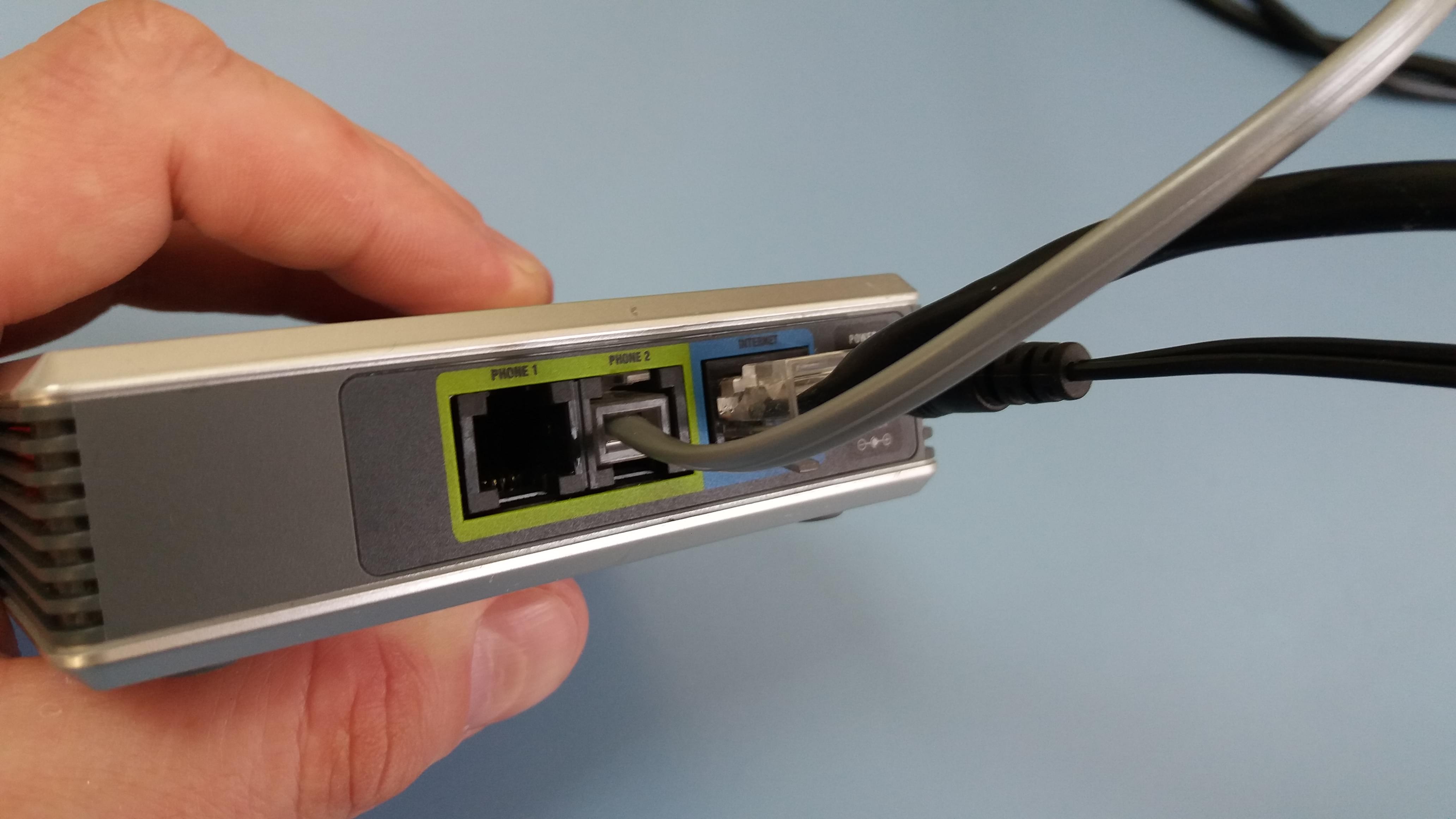 图为 PAP-2T 的侧面，可见 1 个 RJ45 网络接口和 2 个 RJ11 FXS 接口 <br> Антон Пищулин, CC BY-SA 4.0, via Wikimedia Commons